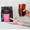 A person holding New Moon coffee and an iced coffee