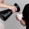 Person pouring coffee into a cup