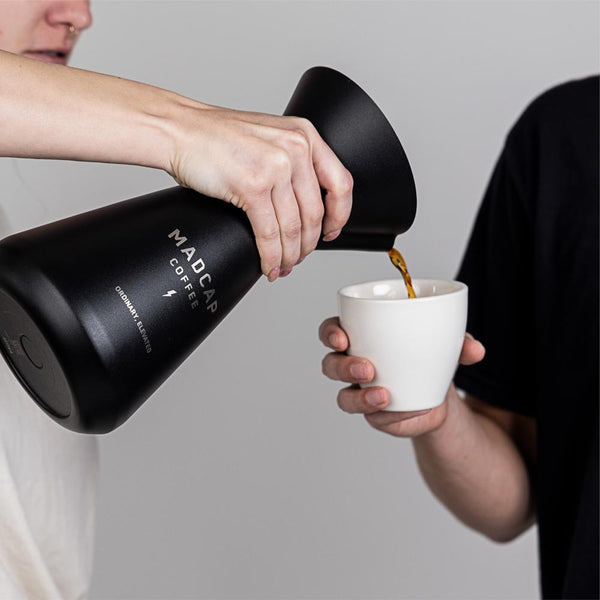 Person pouring coffee into a cup